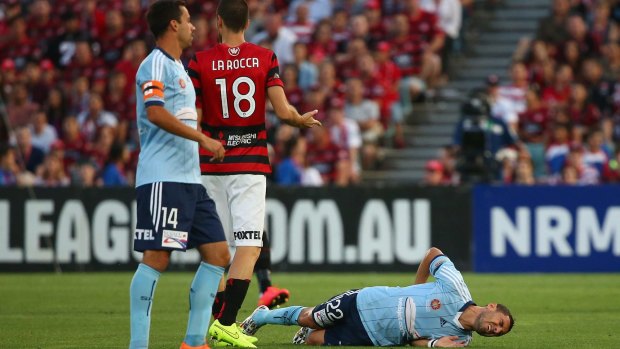 Ouch: Sydney FC star Ali Abbas lies on the Pirtek Stadium turf after suffering a season-ending injury in the tackle of Western Sydney Wanderers' Iacopo la Rocca.