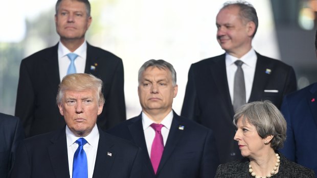 Mr Trump and Prime Minister Theresa May with other NATO leaders at the meeting.