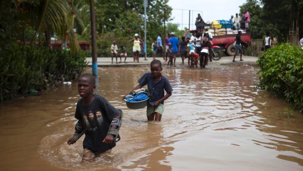 Boys wade through flood waters caused by heavy rains brought on by Hurricane Irma, in Fort-Liberte, Haiti.