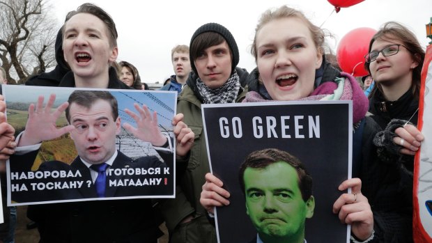 Protesters hold posters depicting Russian Prime Minister Dmitry Medvedev, whom Mr Navalny has accused of corruption.