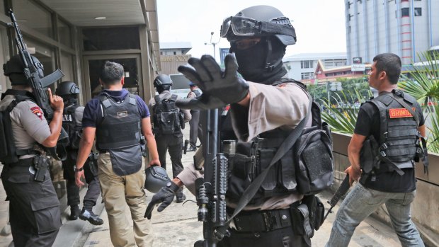 Police search buildings near the site of an explosion in Jakarta on January 14.