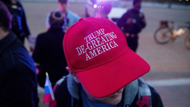 A man wears a hat that reads "Trump De-Greating America" as people gathered for a protest against President Donald Trump's new travel ban order in Lafayette Park outside the White House earlier this month.