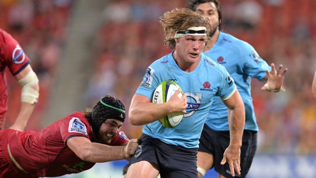 Flying Blue Michael Hooper breaks through the Reds' defence for the Waratahs.