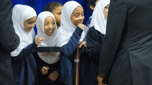 Young girls close their hands in anticipation of "fist-bumping" President Barack Obama, right, in Baltimore on Wednesday.