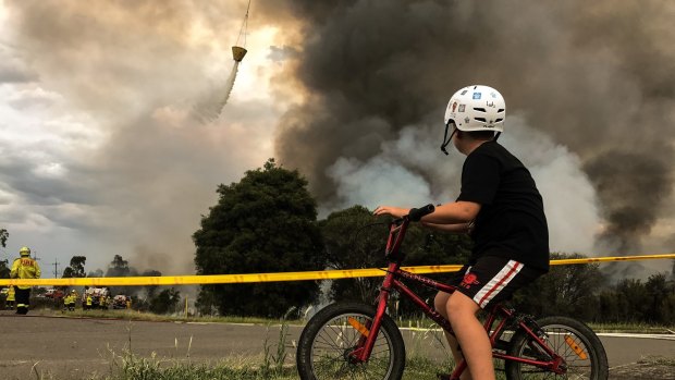 Luke, aged 11, watches the fires as they burn near his home.