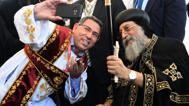 Pope Tawadros II poses for a selfie photograph with deacons from his church after a foundation stone ceremony at the site of the new building and headquarters of his Sydney Diocese.