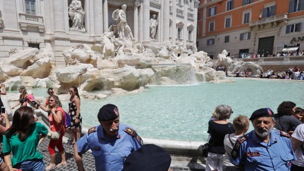 Volunteers control the flow of visitors to the Trevi Fountain in Rome this week.