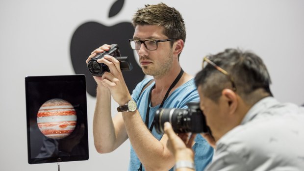 Event attendees take photographs of the new Apple iPad Pro.