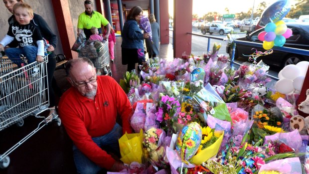 Jim Boulton leaves a floral tribute to Andrea Lehane at Carrum Downs shopping centre on Friday evening. 