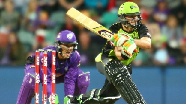 Mike Hussey of the Thunder bats as wicketkeeper Tim Paine of the Hurricanes looks on.