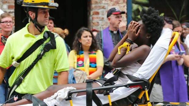 Rescue personnel help an injured woman after a car ran into a large group of protesters during the violence in Charlottesville.