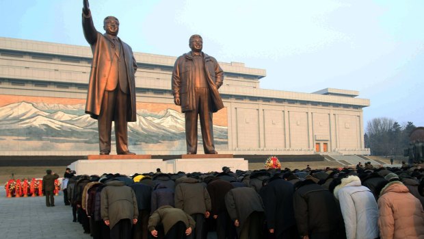 Crowds bow to the statues of North Korea's late leader Kim Jong-il, right,  and his father, North Korea's founder Kim Il-sung, which tower over the capital Pyongyang on a hill.