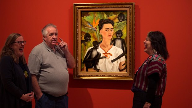 Artist Wendy Sharpe, curator Ann Ryan and head packer Steve Peters in front of Frida Kahlo's self-portrait. 