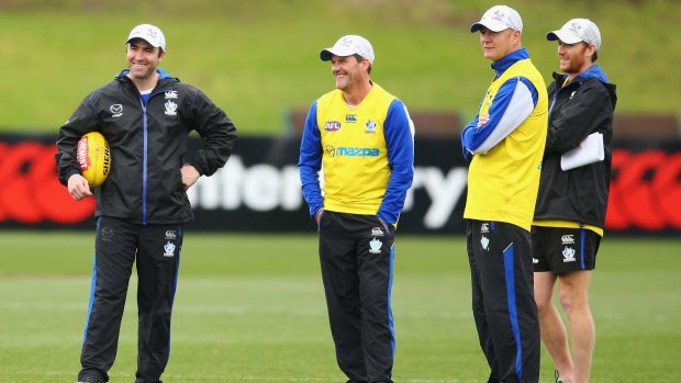 Kangaroos coach Brad Scott with his assistants during a training session on Thursday. 