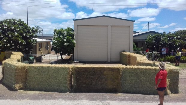 Police boxed in a crocodile at Karumba with hay bales and wheelie bins while waiting for wildlife experts from Cairns to arrive on New Year's Eve.