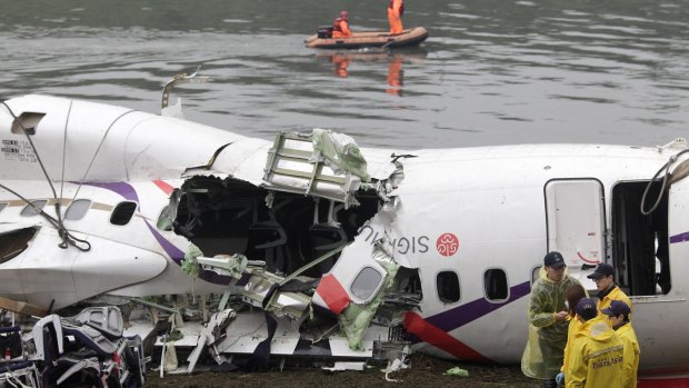 Rescue personnel search in the waters near the wreckage of TransAsia Airways plane Flight GE235 after it crash landed into a river.