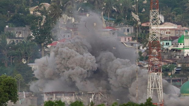 A cloud of debris rises as Philippine Air Force fighter jets bomb suspected locations of Islamist militants in Marawi  on June 9.