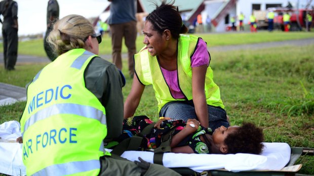 Australian doctors helping in the aftermath of Cyclone Pam give medical aid to a young girl on the Vanuatu island of Tanna.