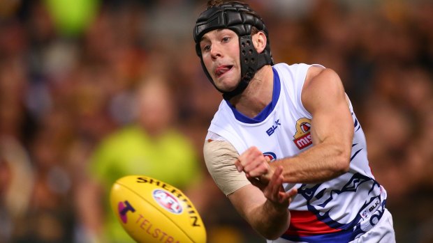 Caleb Daniel of the Bulldogs handballs during the Dogs' win.