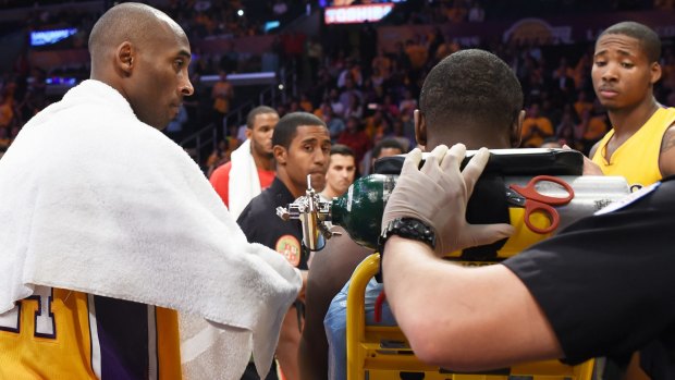 Stretchered off: Julius Randle is taken away by medical staff alongside Lakers teammate Kobe Bryant.