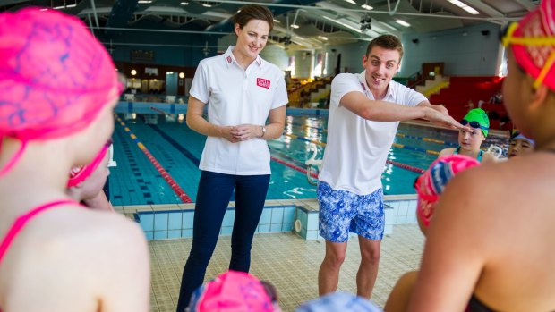 Matt Cowdrey joins Cate Campbell in giving young children swimming tips in Canberra last year.