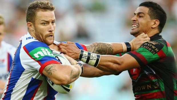 Cody Walker of the Rabbitohs locked in battle with Korbin Sims of the Knights.