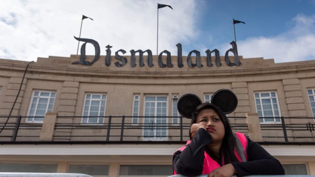 Gloomy ... a steward gets into the spirit of Banksy's new theme park.