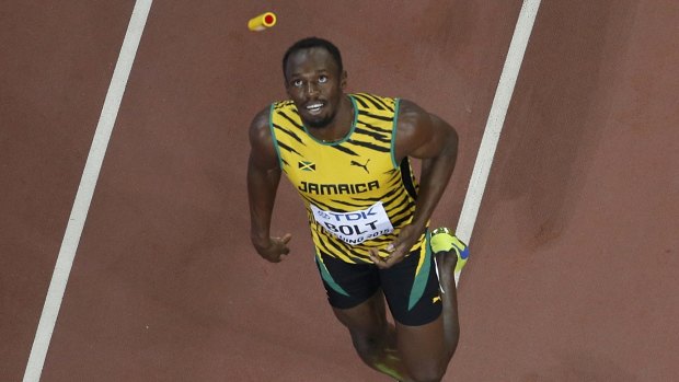 Usain Bolt throws the baton up after the race.