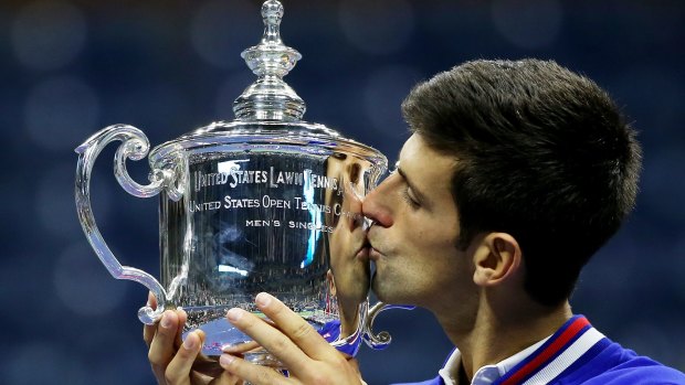 Novak Djokovic of Serbia celebrates with the winner's trophy after defeating Roger Federer of Switzerland at the 2015 US Open.