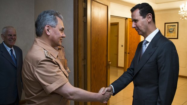 Syrian President Bashar al-Assad shakes hands with Mr Shoigu in Damascus.