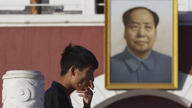 Smoking near a portrait of late Chinese leader Mao Zedong hung on a replica of the Tiananmen Gate in Yinchuan in north-western China's Ningxia Hui autonomous region this week. 
