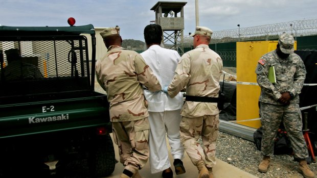 A Guantanamo prisoner escorted by US military personnel at the Guantanamo prison in 2007.