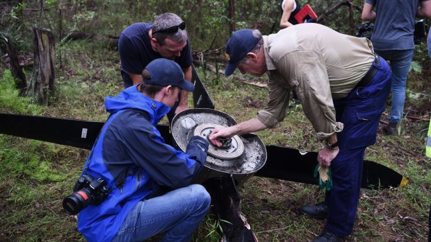 ATSB investigators and police examine the propeller that fell off an aircraft on approach to Sydney Airport.