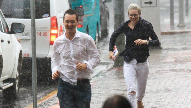 Pedestrians run for shelter from the rain in the CBD.