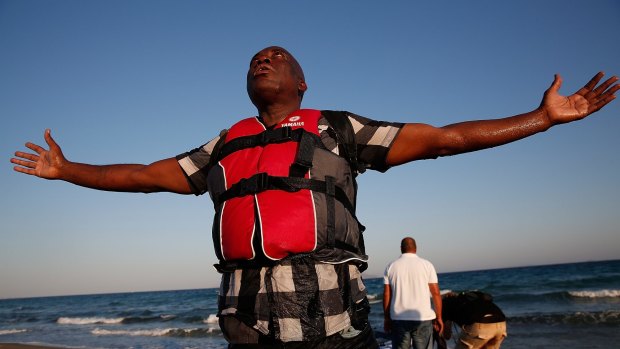 A migrant from Gambia praises Allah in Kos, Greece, after safely completing a journey across the Aegean Sea in a small boat from Turkey in August.