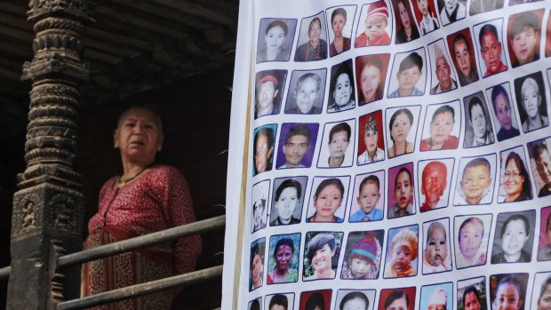 A Nepalese woman stands near photographs of victims of the 2015 earthquakes during a rally in Bhaktapur, Nepal.