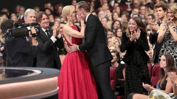 Nicole Kidman congratulates her co-star Alexander Skarsgard with a kiss on the lips at the Emmys while husband Keith Urban claps his congratulations.