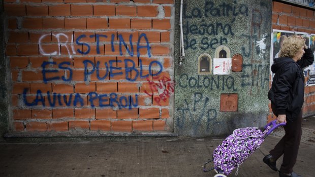 "All possibilities are open": A pedestrian passes graffiti that reads "Cristina is the people" and "Long live Peron" in the Mataderos neighbourhood of Buenos Aires.