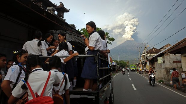 Students go to school as Mount Agung spews smoke and ash in Bali on November 28, 2017.