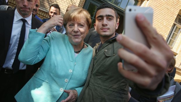 Angela Merkel poses for a selfie with a migrant from Syria. Germany offered a haven for Syrian refugees to ease Europe's migration crisis.