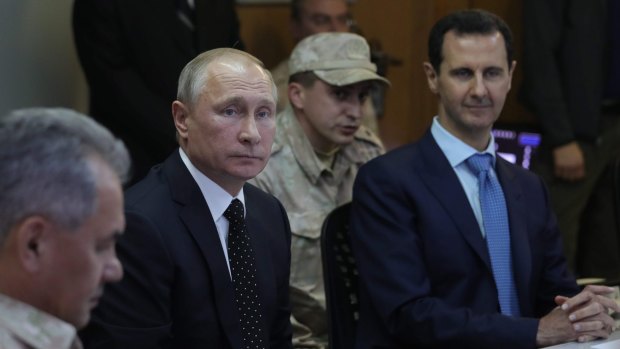 From left, Russian Defence Minister Sergei Shoigu, Russian President Vladimir Putin and Syrian President Bashar Assad attend a meeting at the Hemeimeem air base in Syria earlier this month.