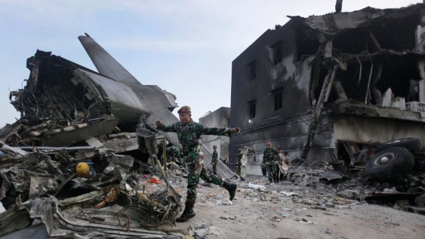 Rescuers search for victims at the site where an Indonesian Air Force transport plane crashed in Medan, North Sumatra, Indonesia.