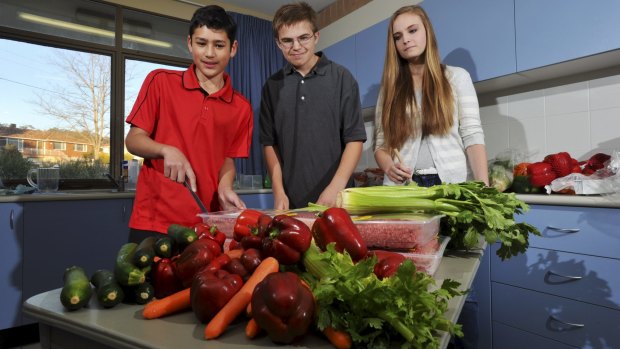 Youth from The Church of Jesus Christ of Latter Day Saints in the church’s kitchen in Garran. From left; Cormack Kikkert, 13, of Charnwood, Joshua Welling, 13, and Evelyn Welling, 15, both of Isaacs. 