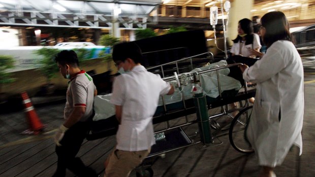 Medical workers rush the victim of a blast at the Erawan Shrine to a nearby hospital in central Bangkok on Monday.