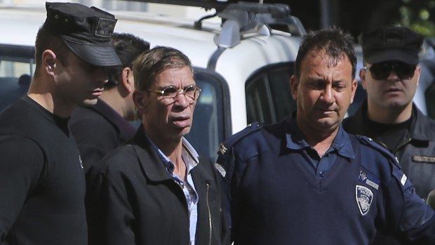 Mustafa is escorted by Cyprus police officers as he leaves the court after a remand hearing.