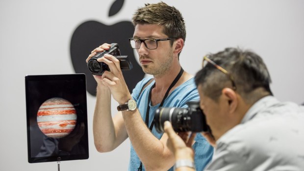 Apple event attendees take photographs of the new Apple iPad Pro.
