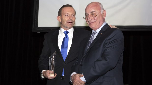 Petro Georgiou receives the Migration Council of Australia's lifetime achievement award from Prime Minister Tony Abbott on Tuesday night.
