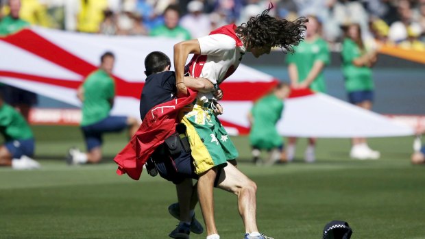 A policeman tackles a pitch invader before the start of the Cricket World Cup final.