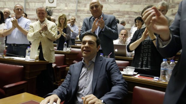 Greek Prime Minister Alexis Tsipras arrives to applause from lawmakers of  his Syriza party.