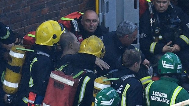 Firefighters rescue a man from the Grenfell Tower fire. 